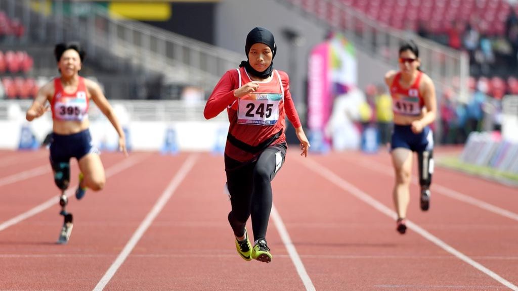 Sprinter Indonesia, Karisma Evi Tiarani (tengah), memacu kecepatan saat berlaga dalam nomor 100 meter putri T42 dan T63 Asian Para Games 2018 di Stadion Utama Gelora Bung Karno, Jakarta, Rabu (10/10/2018).