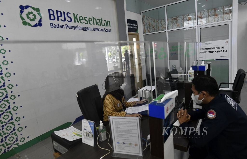 Petugas BPJS Kesehatan melayani warga di salah satu loket di Kantor Cabang BPJS Kesehatan Jakarta Selatan, Jakarta, November 2021.