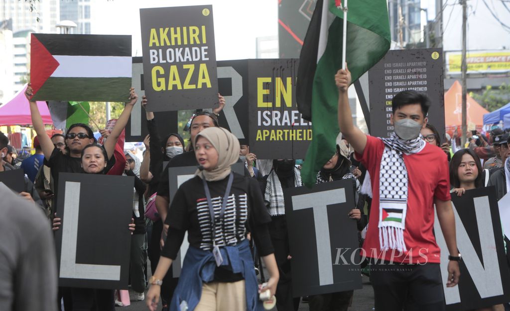 Sejumlah aktivis gabungan Koalisi Masyarakat Sipil menggelar aksi Bela Palestina dengan berparade saat berlangsung hari bebas kendaraan bermotor di kawasan Dukuh Atas, Jalan Sudirman, Jakarta Pusat, Minggu (3/3/2024). 