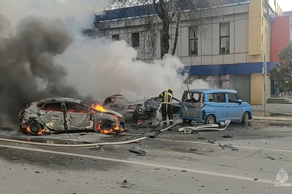 Foto tanggal 30 Desember 2023 ini memperlihatkan upaya petugas pemadam kebakaran memadamkan api yang melahap sebuah mobil menyusul serangan di Belgorod, Rusia. 