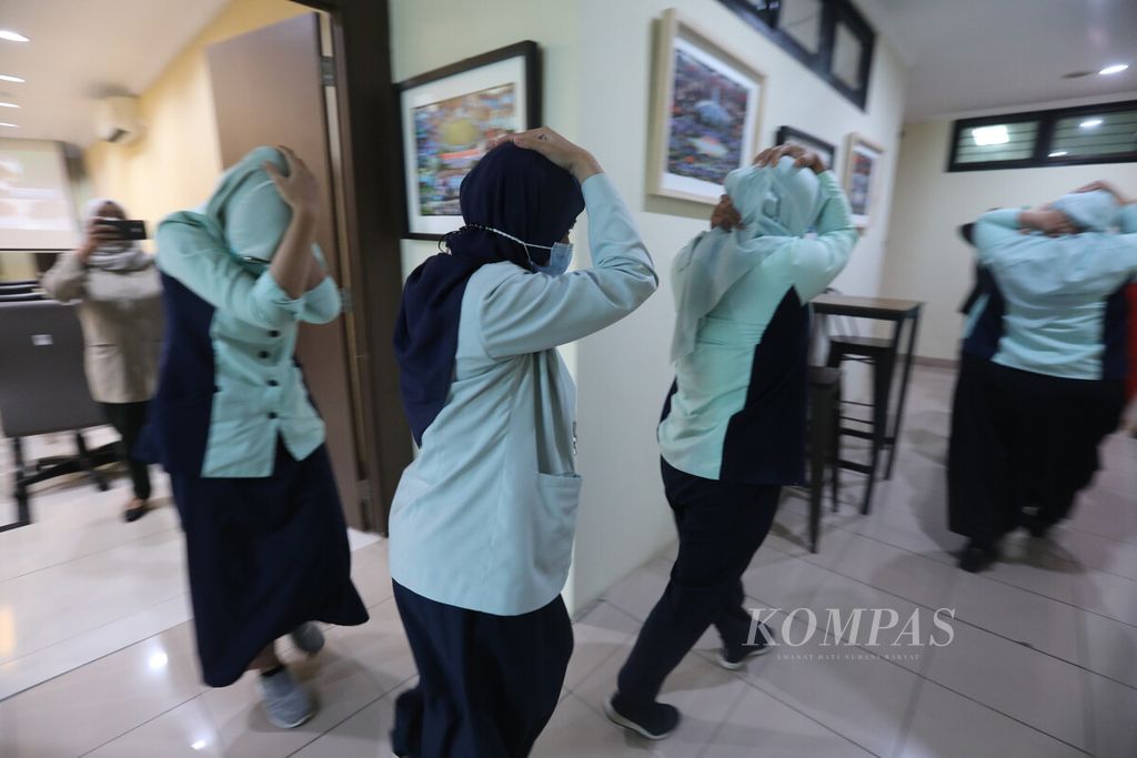 Staf dan petugas keamanan meninggalkan RS dengan posisi perlindungan diri saat berlangsung sosialisasi dan simulasi bencana gempa bumi oleh Badan Penanggulangan Bencana Daerah (BPBD) DKI di RSUD Kemayoran, Jakarta Pusat, Selasa (18/10/2022). 