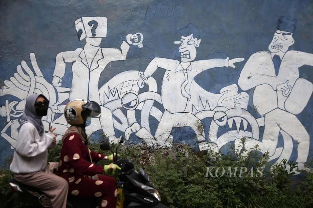 Warga melintas di depan mural bertema penegakan hukum di Setu, Tangerang Selatan, Banten, Selasa (1/2/2022). Salah satu pilar demokrasi adalah bagaimana memastikan institusi penegak hukum bekerja lebih adil, tidak diskriminatif, dan melindungi warga negaranya.
