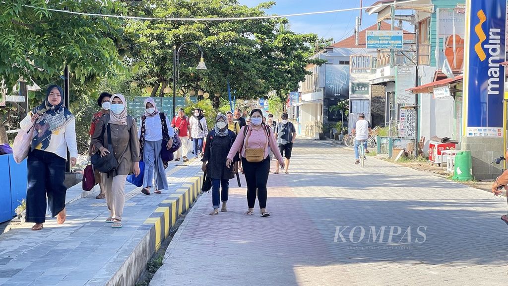 Wisatawan berjalan kaki menuju pelabuhan yang akan membawa mereka kembali ke Lombok daratan setelah berlibur di Gili Trawangan, Lombok Utara, Nusa Tenggara Barat, Minggu (23/1/2022). 
