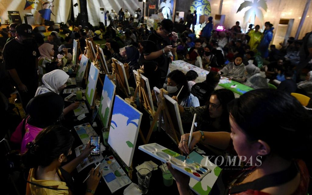 Pengunjung menikmati sesi melukis yang digelar di Joyland Festival 2022 di Stadion Softball Gelora Bung Karno, Jakarta, Jumat (4/11/2022). 