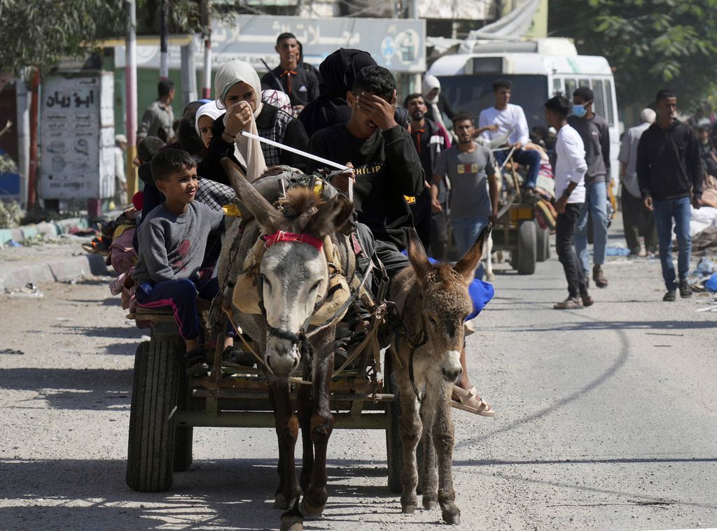 Sebuah gerobak yang dihela seekor keledai menjadi alat transportasi pilihan sebuah keluarga Gaza yang hendak mengungsi ke selatan kota itu, Jumat (13/10/2023). 