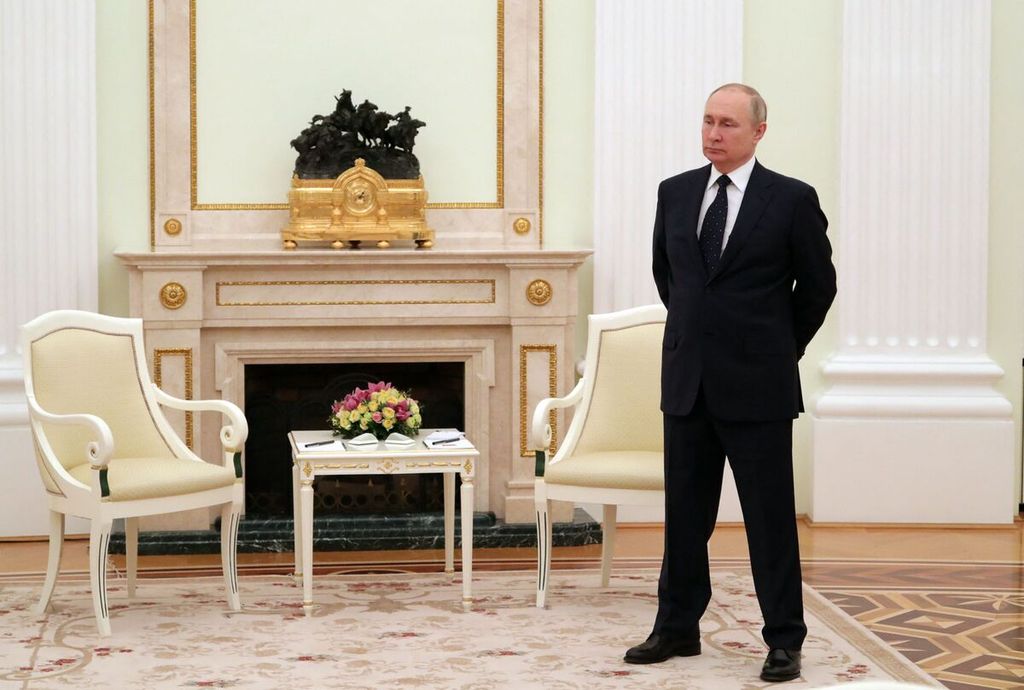 Presiden Rusia Vladimir Putin berdiri di sebuah ruangan hall menjelang pertemuannya dengan Presiden Belarus Alexander Lukashenko di Kremlin, Moskwa, Rusia, 11 Maret 2022.  