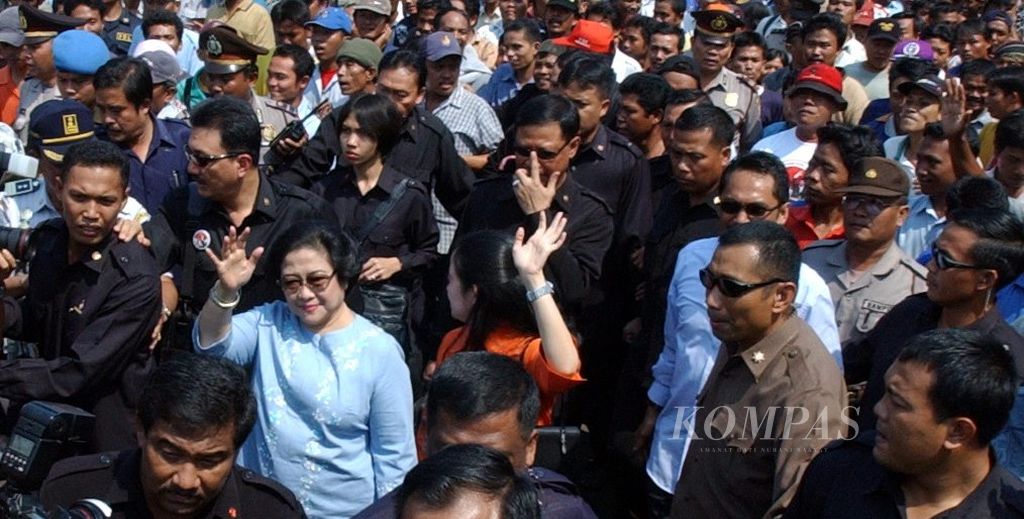 Presidential candidate from the Indonesian Democratic Party of Struggle (PDI-P), Megawati Soekarnoputri, walked while waving her hand followed by hundreds of people who tried to get close during the 2004 presidential campaign at Pulogadung Terminal, East Jakarta, on Tuesday (2/5/2004).