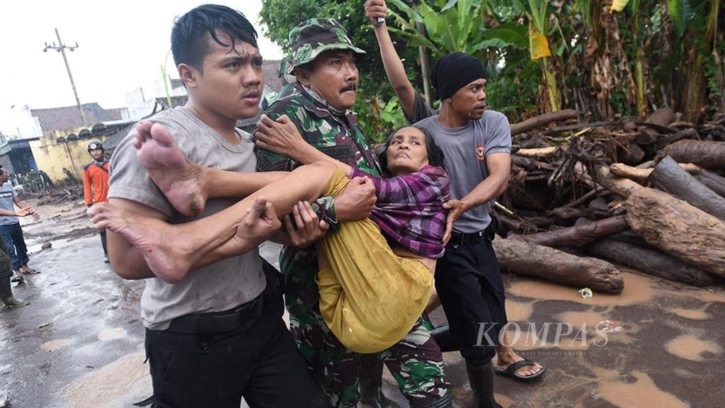 Anggota TNI dan polisi mengevakusi Rukyati yang terserang stroke di lokasi banjir bandang material vulkanik Gunung Raung di Dusun Garit, Desa Alas Malang, Kecamatan Singojuruh, Kabupaten Banyuwangi, Minggu (24/6/2018). 