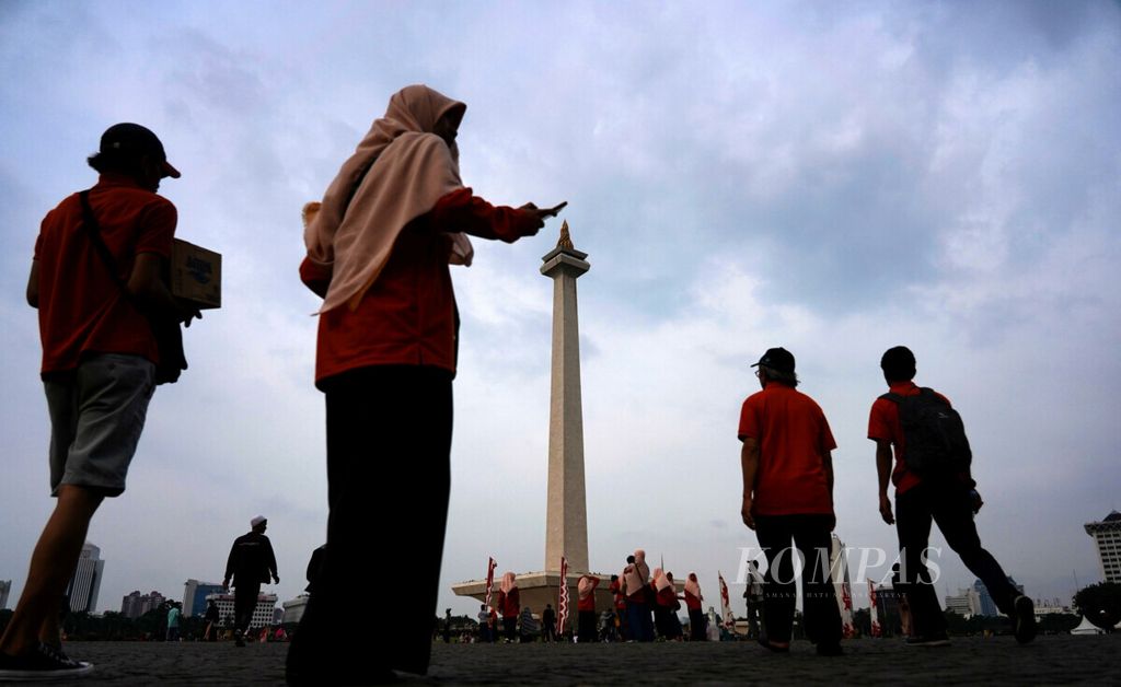 Sejumlah warga beramai-ramai mengunjungi Monumen Nasional, Jakarta, untuk mengisi waktu liburan, Sabtu (22/12/2018). Bersamaan liburan sekolah, kawasan wisata Monas ramai pengunjung dari banyak daerah.