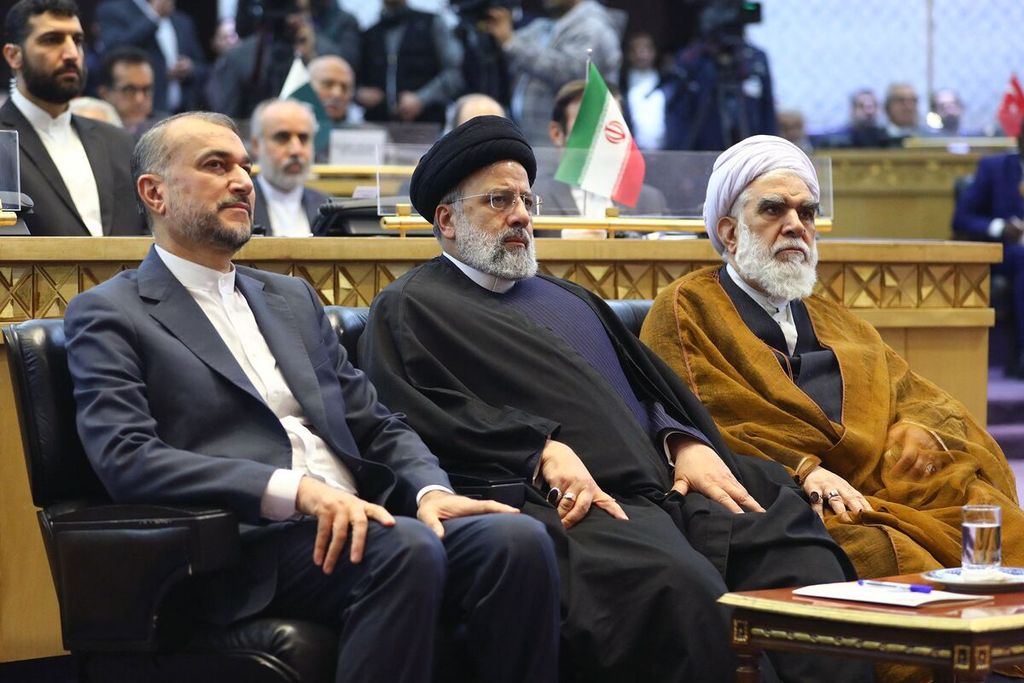 Iran's Foreign Minister Hossein Amir-Abdollahian (left) and President Ebrahim Raisi (center) during an event in Tehran, Iran, in December 2023. They were killed in a helicopter accident on Sunday (19/5/2024).