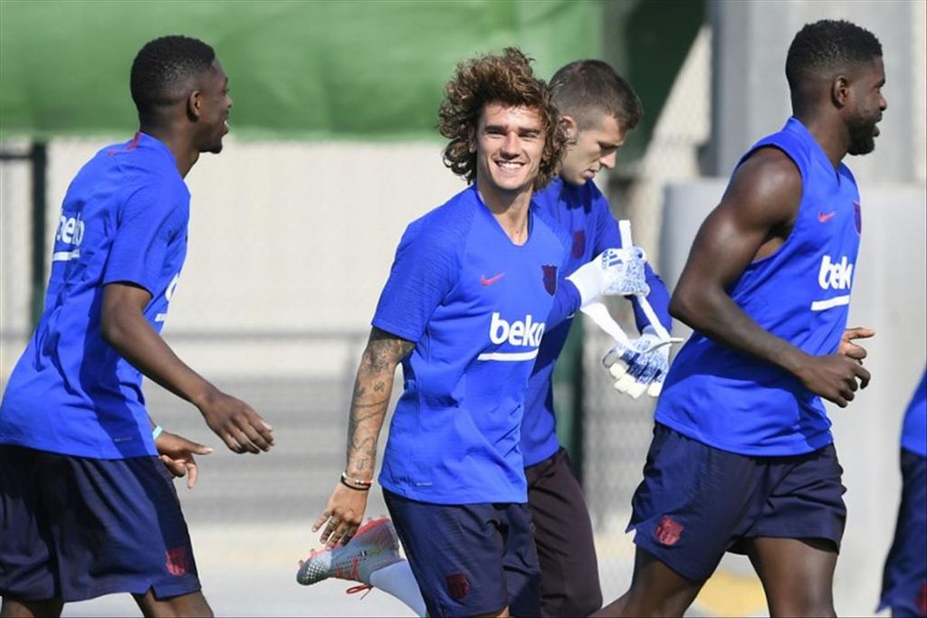 Barcelona's French attacker, Antoine Griezmann (second from the left), laughs while participating in the first pre-season training session at the Joan Gamper training center in Sant Joan Despi, Barcelona, Spain, on Monday (15/7/2019).