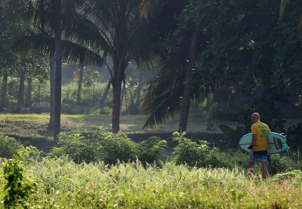 Peselancar dari mancanegara berjalan kaki sambil membawa papan selancar saat meninggalkan Pantai Cimaja, Kabupaten Sukabumi, Jabar, Rabu (24/5/2023). Pantai Cimaja memiliki ombak besar dan khas yang cocok untuk olahraga selancar ombak. 