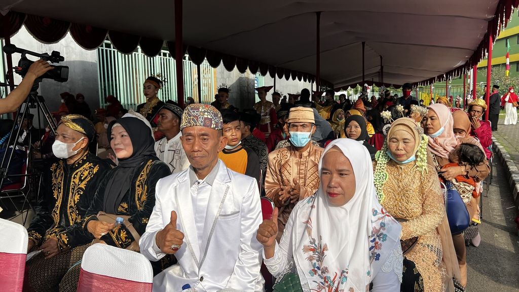 Pasangan pengantin isbat nikah bersama keluarga menikmati suguhan acara yang dipersiapkan Pemerintah Kota Bekasi di halaman Stadion Patriot Chandrabaga, Kota Bekasi, Jawa Barat, Minggu (4/12/2022).