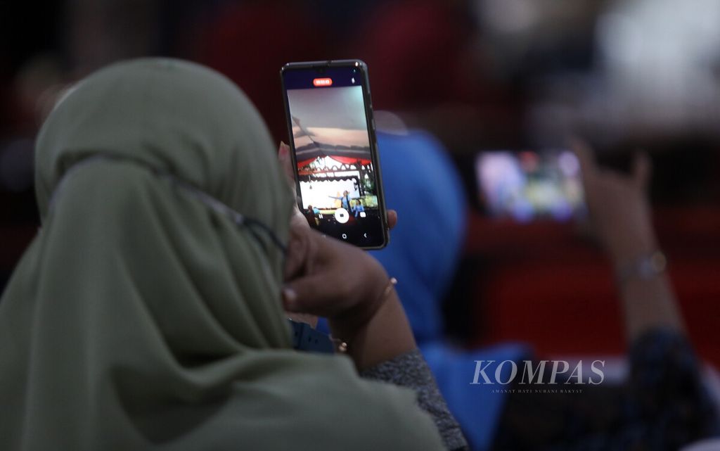 Penonton merekam aksi dalang cilik Ki Danesworo Rafi Ramadhan dalam pergelaran wayang kulit milenial  dengan lakon "Babad Wanamarta" di kompleks Kementerian Koordinator Bidang Pembangunan Manusia dan Kebudayaan, Jakarta, Jumat (4/11/2022). 