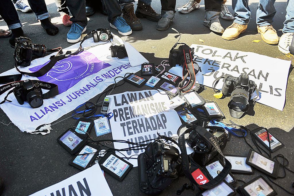 Sejumlah wartawan meletakkan kartu pers dan peralatan liputan sebagai bentuk protes terhadap aksi kekerasan terhadap jurnalis saat unjuk rasa di depan Monumen Bajra Sandhi, Denpasar, Bali, Selasa (7/7/2015). 
