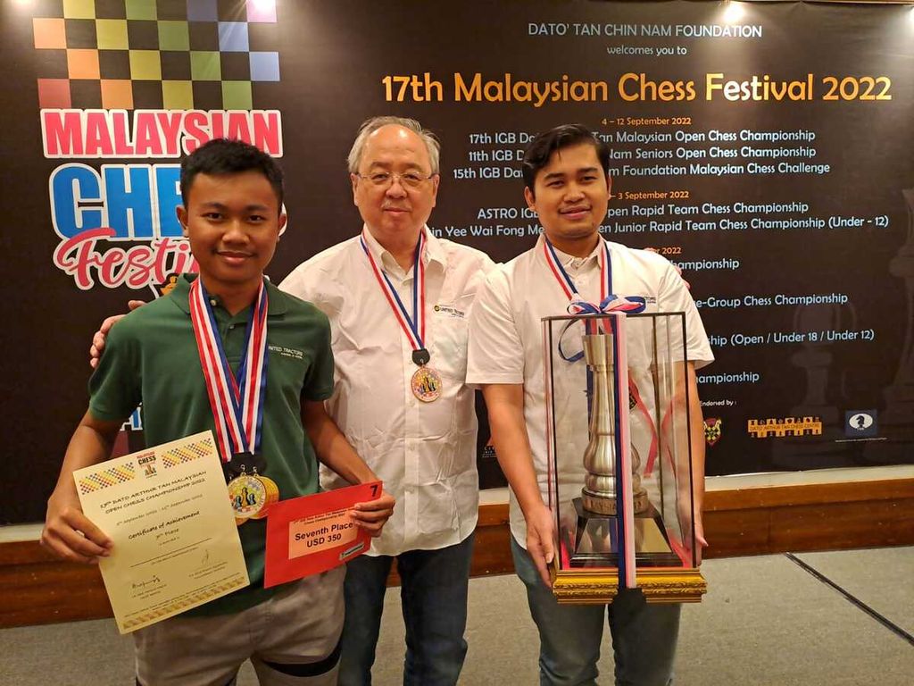 Pecatur Indonesia FM Aditya Bagus Arfan (kiri) dan GM Novendra Priasmoro, didampingi manajer tim Kristianus Liem, memamerkan trofi dan penghargaan setelah menjuarai turnamen catur Malaysia Terbuka, Minggu (11/9/2022), di Kuala Lumpur, Malaysia.