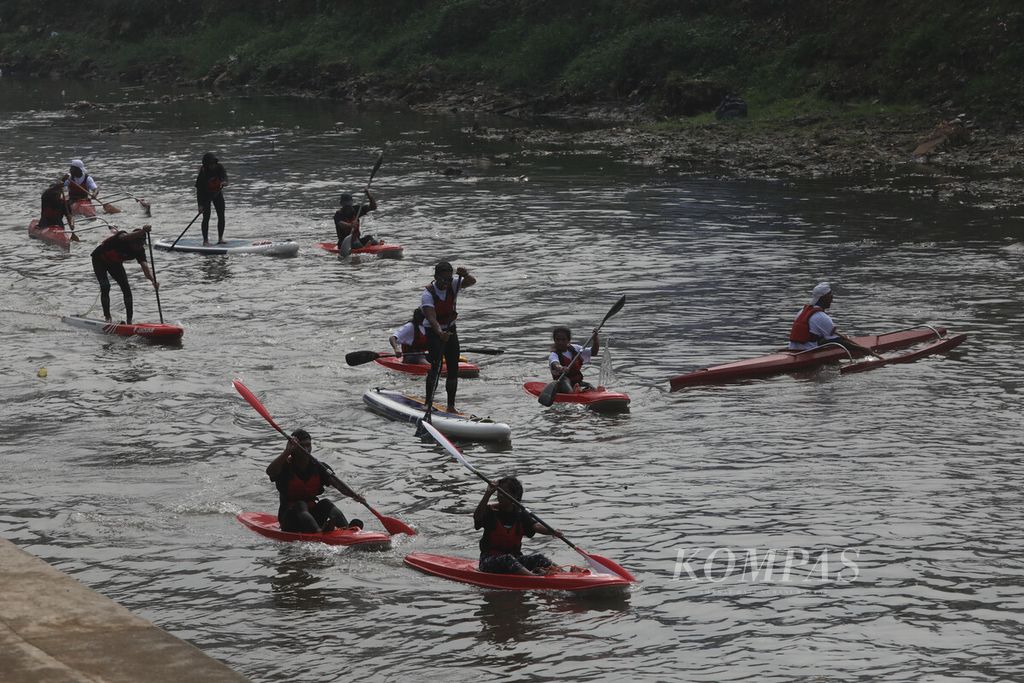 Participants in the river clean-up action rowed canoes on the Ciliwung River, Cawang, Jakarta, while taking part in the River Milking action, Thursday (27/7/2023).