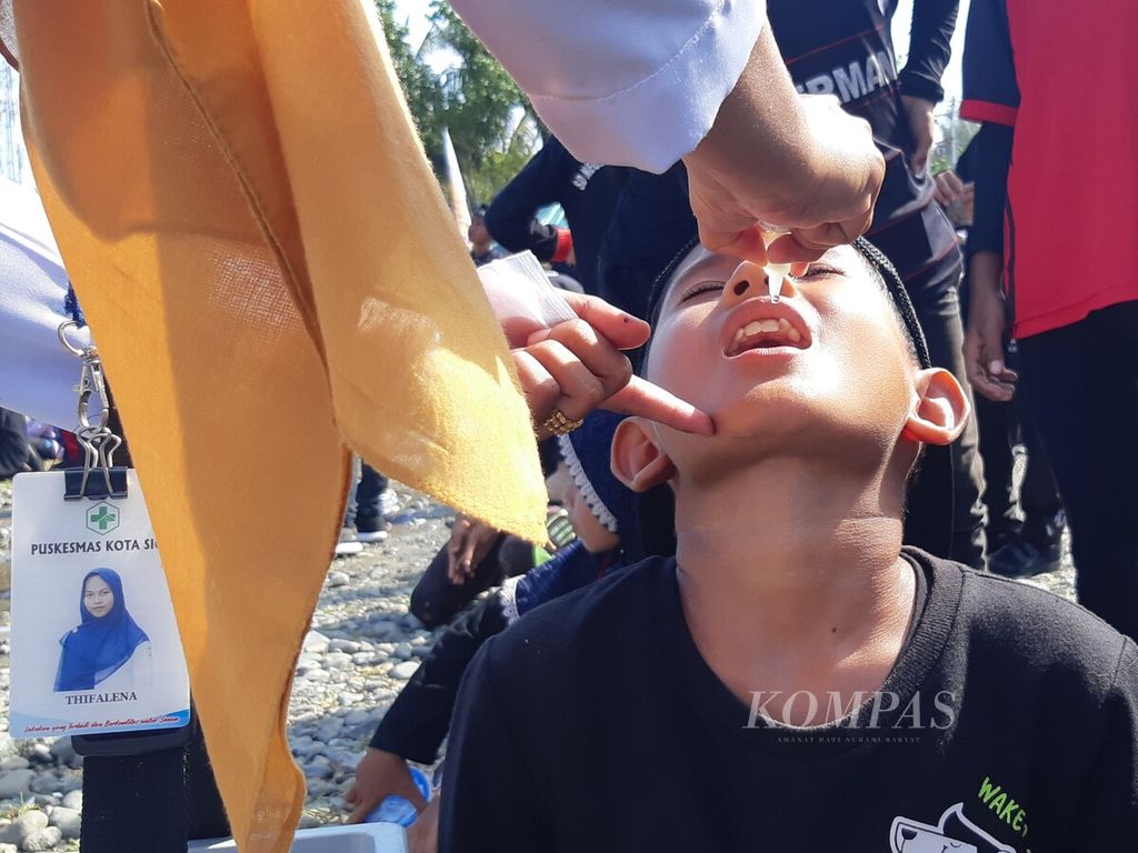 Para tenaga kesehatan meneteskan imunisasi polio kepada salah seorang anak sekolah dasar dalam sub-pekan imunisasi nasional di Kabupaten Pidie, Provinsi Aceh, Senin (28/11/2022). Imunisasi massal dilakukan pascapenemuan empat kasus postif polio di kabupaten itu.