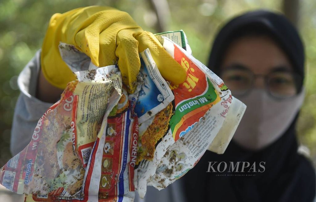 Aktivis lingkungan dari Ecological Observation and Wetlands Conservation (Ecoton) menunjukkan sampah plastik yang ia kumpulkan saat melakukan bersih-bersih pesisir dalam rangka World Cleanup Day di Kawasan Hutan Mangrove Wonorejo, Surabaya, Jawa Timur, Minggu (19/9/2021). 