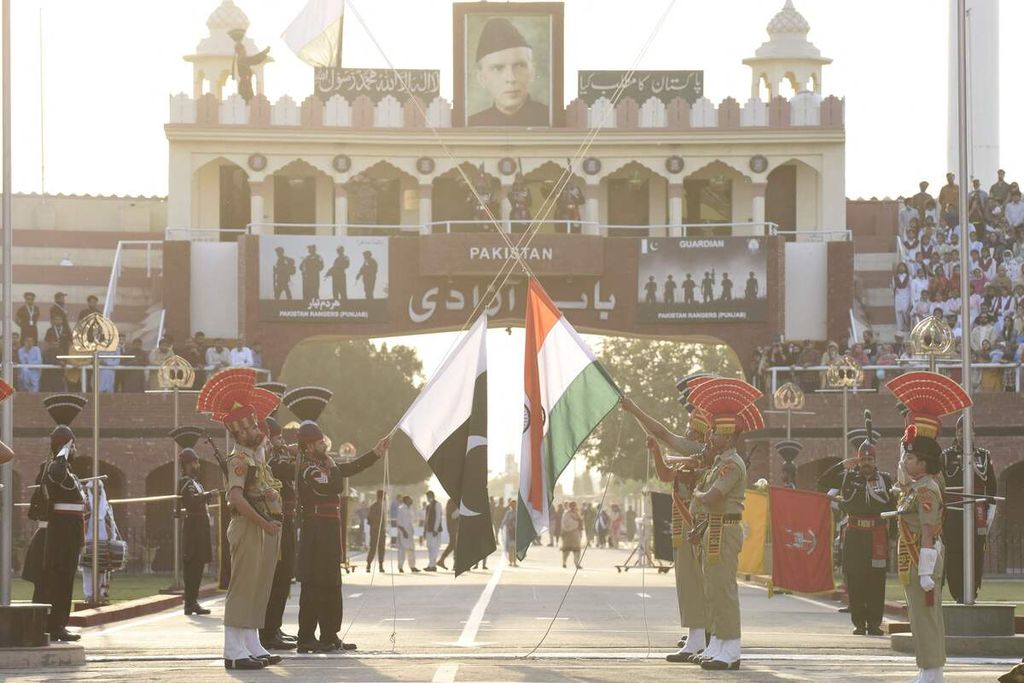 Pasukan keamanan penjaga perbatasan India (seragam coklat) dan pasukan Ranger Pakistan (seragam hitam) ambil bagian dalam sebuah upacara di pos perbatasan India-Pakistan di Wagah, sekitar 35 kilometer dari Amritsar, India, 9 Maret 2022. 