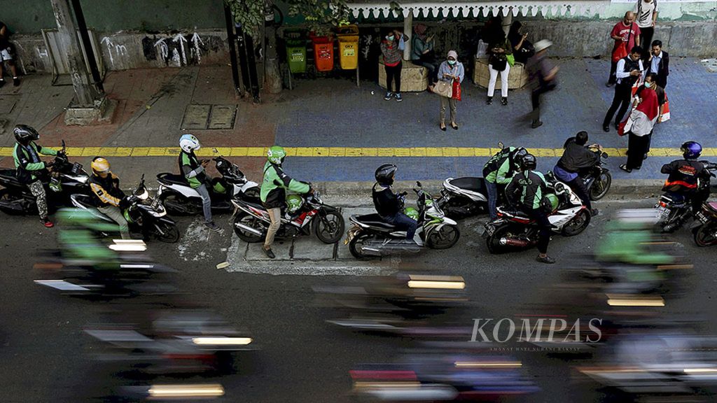 Pengemudi ojek daring menurunkan dan menunggu penumpang di sekitar Stasiun Palmerah, Jalan Tentara Pelajar, Jakarta, Rabu (16/8).