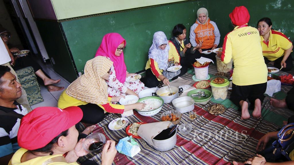 Sejumlah buruh pabrik rokok bagian linting dan gunting makan siang di rumah salah satu rekan mereka di Karangploso, Malang, Jawa Timur, Rabu (1/11). Buruh rokok yang bekerja 7 jam sehari ini mendapat upah minimal Rp 1 juta per minggu.