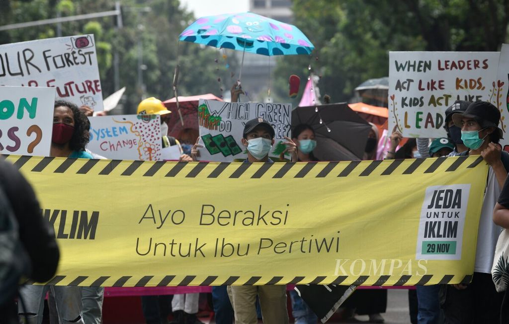Aktivis lingkungan menggelar kampanye Jeda untuk Iklim yang menyuarakan ancaman krisis iklim bumi di kawasan Jalan Medan Merdeka Selatan, Jakarta, Jumat (27/11/2020). Aksi yang diikuti anak muda tersebut merupakan bagian dari Asia Climate Strike yang dilaksanakan serentak di sejumlah negara Asia.