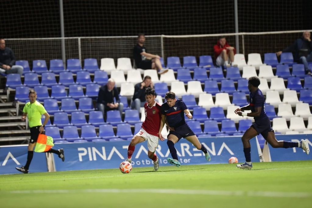 Pemain tim sepak bola Indonesia U-20, Muhammad Dzaky Asraf, berduel dengan pemain tim Perancis U-20 dalam laga uji coba di Pinatar Arena Football Center, Murcia, Spanyol, Kamis (18/11/2022). Indonesia kalah telak, 0-6, dari Perancis pada laga tersebut.