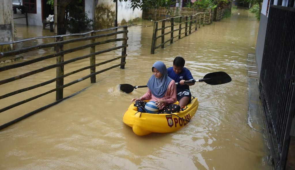 Anek menaiki kano saat banjir di Desa Blega, Kecamatan Blega, Kabupaten Bangkalan, Jawa Timur, Minggu (1/1/2023). Banjir mulai terjadi pada Sabtu (31/12/2022) siang dan membesar hingga Minggu dini hari. 