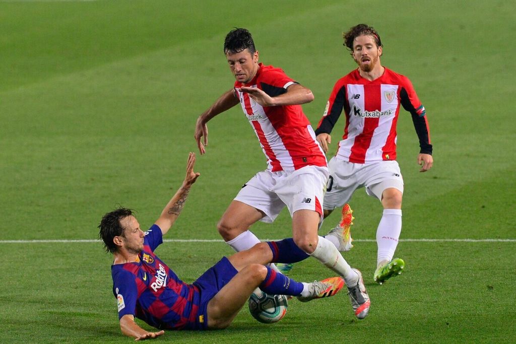 Pemain Barcelona Ivan Rakitic (kiri) berebut bola dengan pemain Athletic Bilbao Mikel Vesga (tengah) dan Iker Muniain (kanan) pada laga Liga Spanyol di Stadion Camp Nou, Barcelona, 23 Juni 2020.