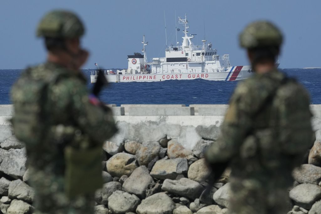Pasukan Filipina mengawasi kapal Penjaga Pantai Filipina saat mengamankan area di Pulau Thitu, 1 Desember 2023. 