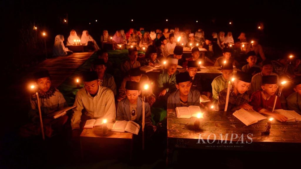 Santri Pondok Pesantren Nurul Hidayah Al-Mubarokah mengaji dengan penerangan lampu minyak di Dusun Tempel, Desa Sempu, Kecamatan Andong, Kabupaten Boyolali, Jawa Tengah, Senin (20/5/2019). Pengajian tersebut untuk menyambut malam Nuzulul Quran pada 17 Ramadhan 1440 Hijriah.