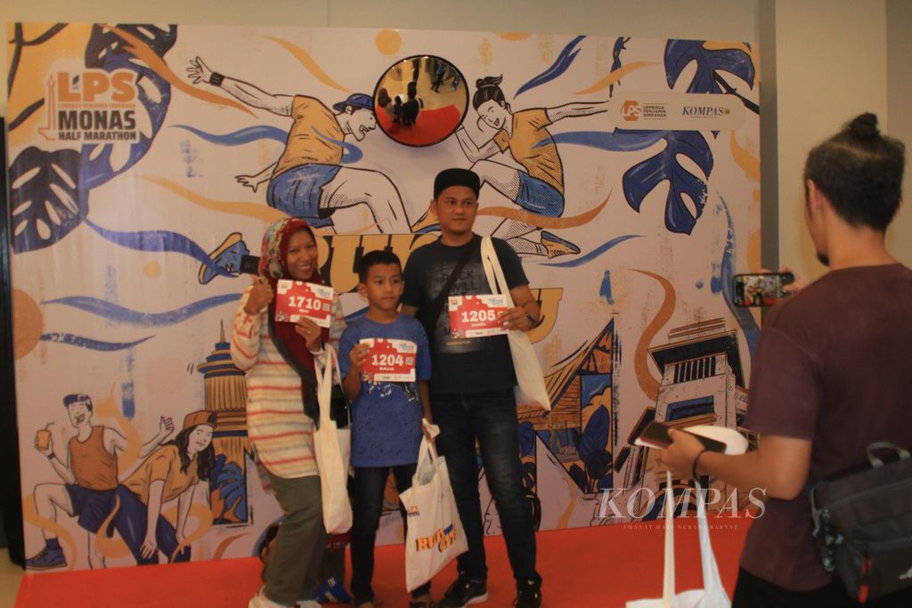 Nur Hasanah Nasution with her children and husband take a photo together while taking the race pack for Run The City Medan, North Sumatra, Saturday (4/5/2024). Run The City is a series of events from the 2024 LPS Monas Half Marathon which will be held in Jakarta, Sunday (30/6/2024).