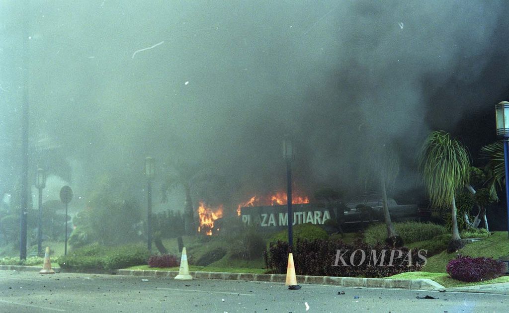Api masih membakar sejumlah mobil di depan lobi Hotel JW Marriott (6/8/2003). Selain membakar 22 mobil, menewaskan 10 orang, dan mencederai puluhan orang lainnya, bom mobil itu juga merusak Plaza Mutiara.