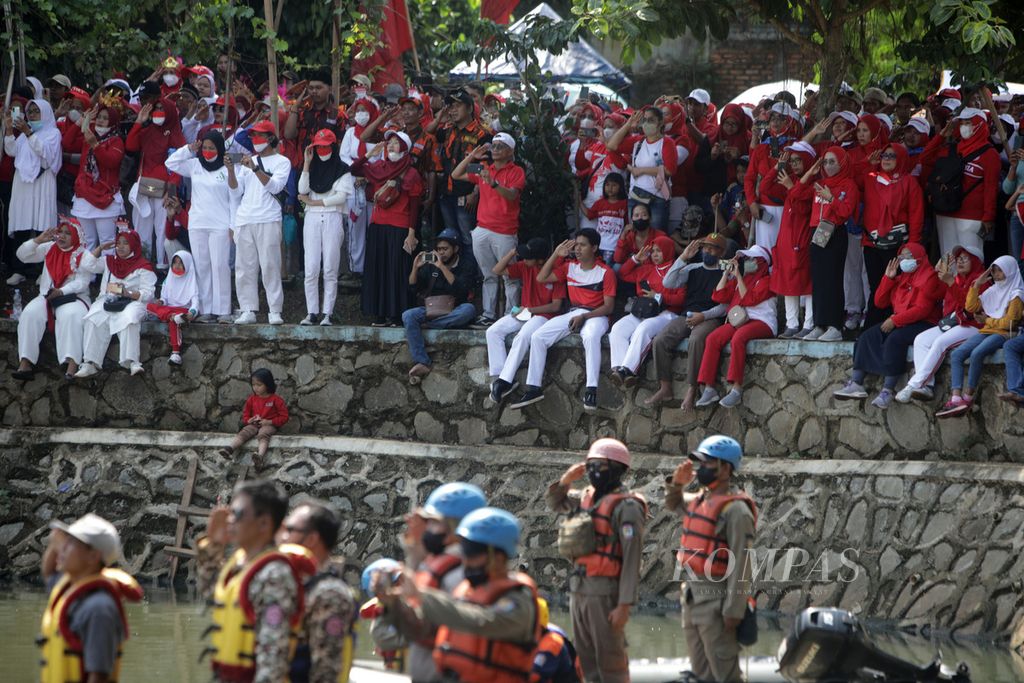 Warga yang hadir memberikan hormat kepada bendera Merah Putih saat upacara bendera memperingati HUT Ke-77 Kemerdekaan Indonesia di Setu Parigi, Tangerang Selatan, Banten, Kamis (18/8/2022). Upacara ini digelar dalam rangkaian acara Pondok Aren Berkibar yang melibatkan seluruh komponen masyarakat. 