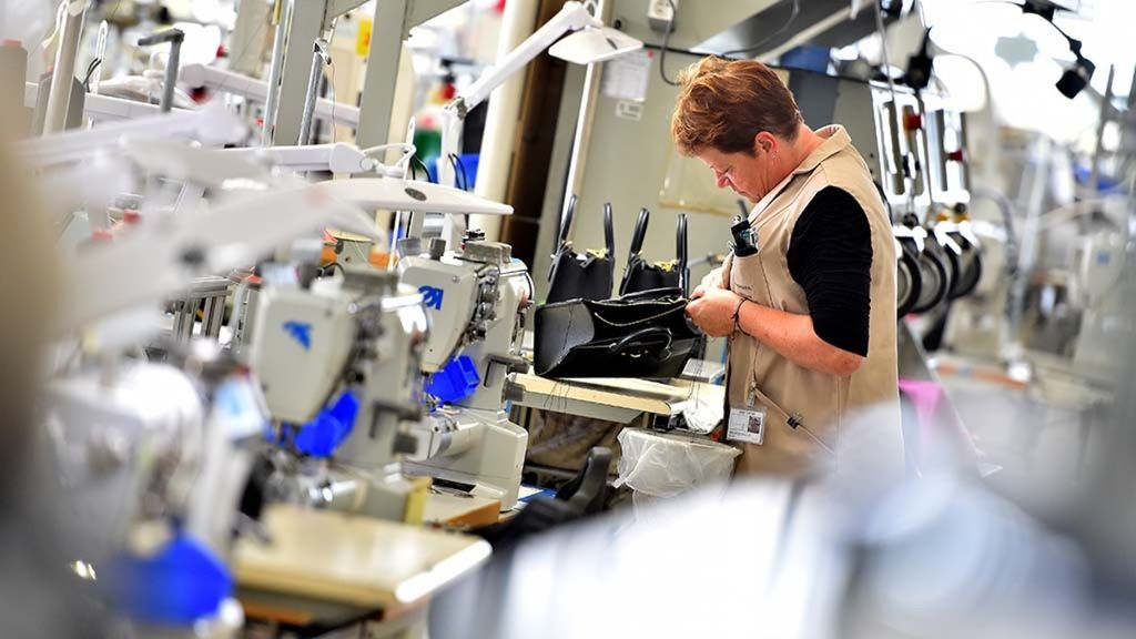 Pekerja perempuan tengah mengerjakan tas jinjing kulit Louis Vuitton di pabriknya di Juilley, Perancis, Jumat (12/10/2018).  Louis Vuitton menjadi salah satu merek yang diburu konsumen China.