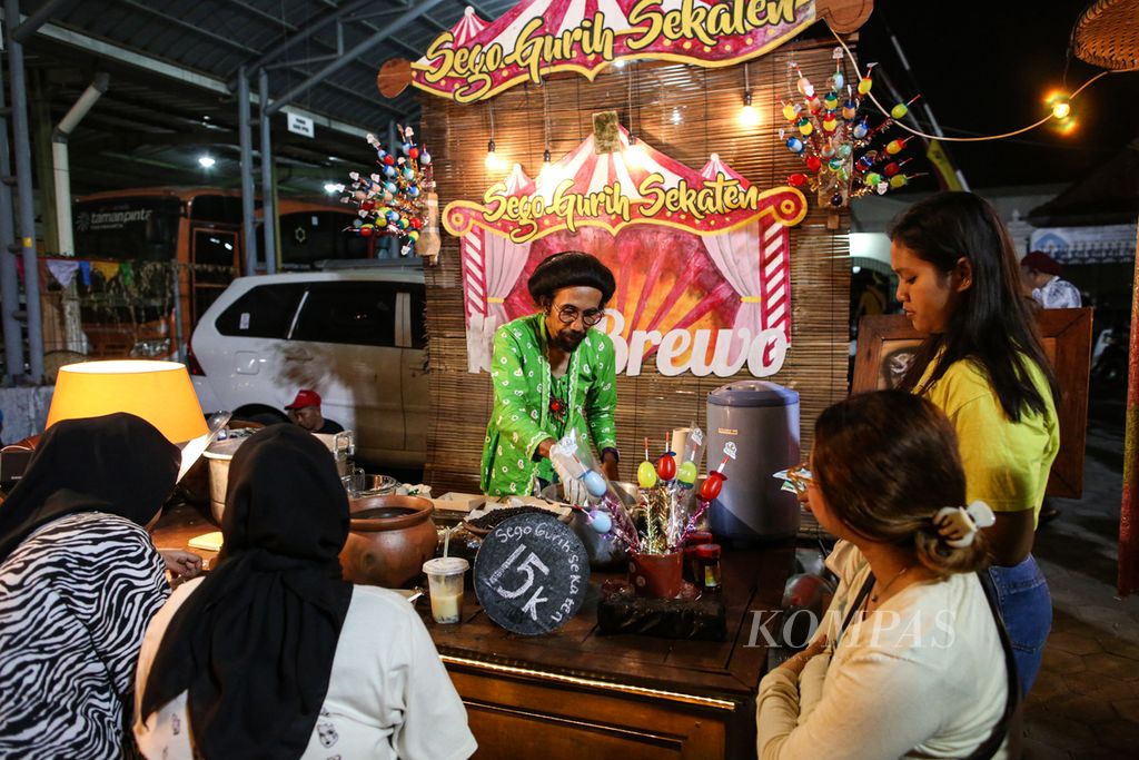 Pedagang sego gurih sekaten melayani pembeli dengan berpenampilan nyentrik di Pasar Kangen Jogja 2023 di Taman Budaya Yogyakarta, Kota Yogyakarta, Rabu (2/8/2023) malam. 