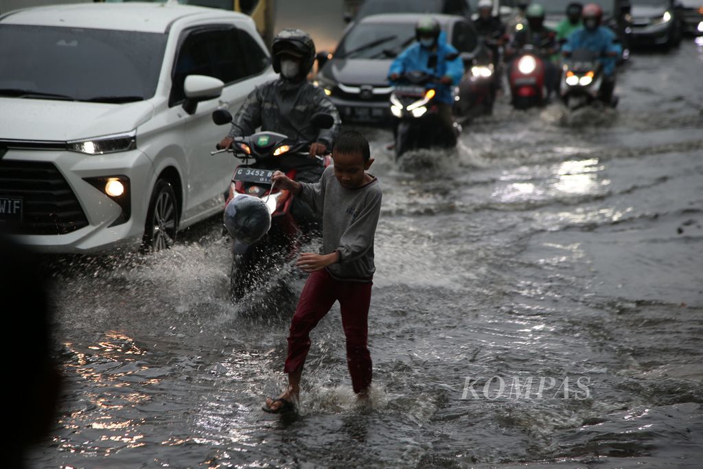 Pengendara menembus genangan air saat hujan deras mengguyur kawasan Gandaria, Jakarta Selatan, Jumat (22/4/2022). Genangan setinggi 15 sentimeter itu menyebabkan lalu lintas di Jalan Sultan Iskandar Muda tersendat.