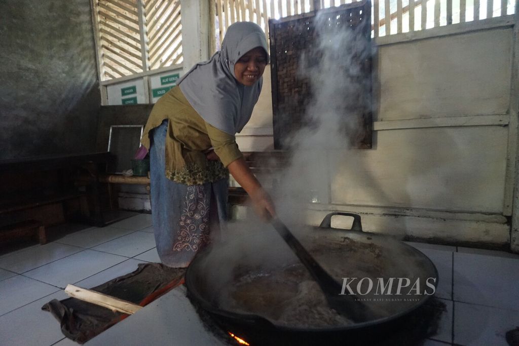 Imah memasak nira kelapa untuk dijadikan gula kelapa semut atau kristal di rumahnya di Desa Semedo, Kecamatan Pekuncen, Kabupaten Banyumas, Jawa Tengah, Kamis (27/7/2023). 