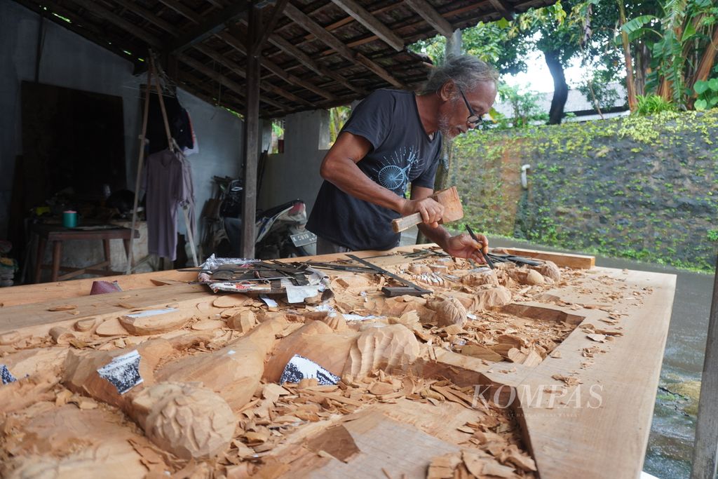 Tumar (67) beraktivitas di sentra ukir dan relief di Desa Senenan, Kecamatan Tahunan, Kabupaten Jepara, Jawa Tengah, Sabtu (28/1/2023). Tumar sudah menekuni seni ukir dan relief sejak usia 10 tahun.