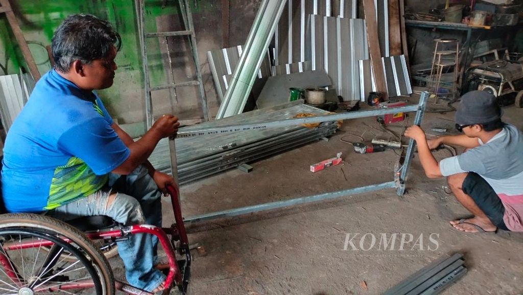 Darmanto (47) memperhatikan kerja yang dilakukan oleh salah seorang karyawannya di bengkel lasnya di Desa Wringinputih, Kecamatan Borobudur, Kabupaten Magelang, Jawa Tengah, Sabtu (1/4/2023).