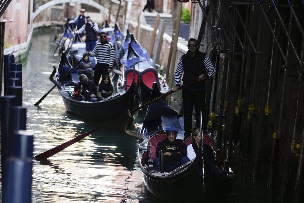 Pelancong di gondola kanal-kanal Venesia, Italia, Rabu (24/4/2024).