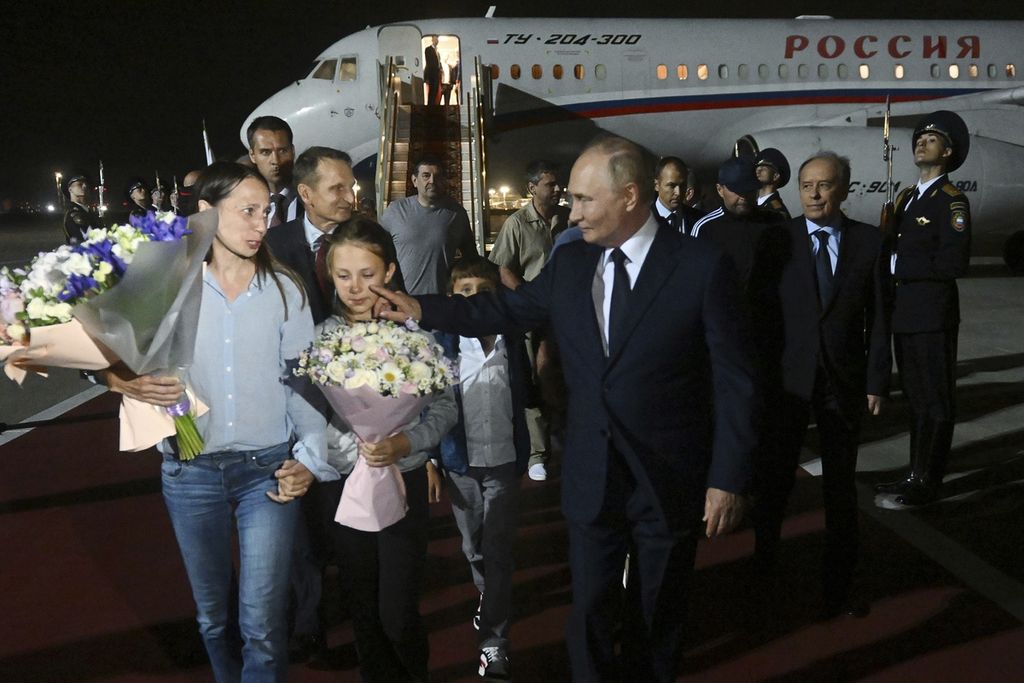 Presiden Rusia Vladimir Putin (kanan) berjalan di samping Sofiya (11) dan keluarganya serta para tahanan Rusia yang dibebaskan saat mereka tiba di Bandar Udara Vnukovo milik pemerintah di luar Moskwa, Rusia, 1 Agustus 2024. 