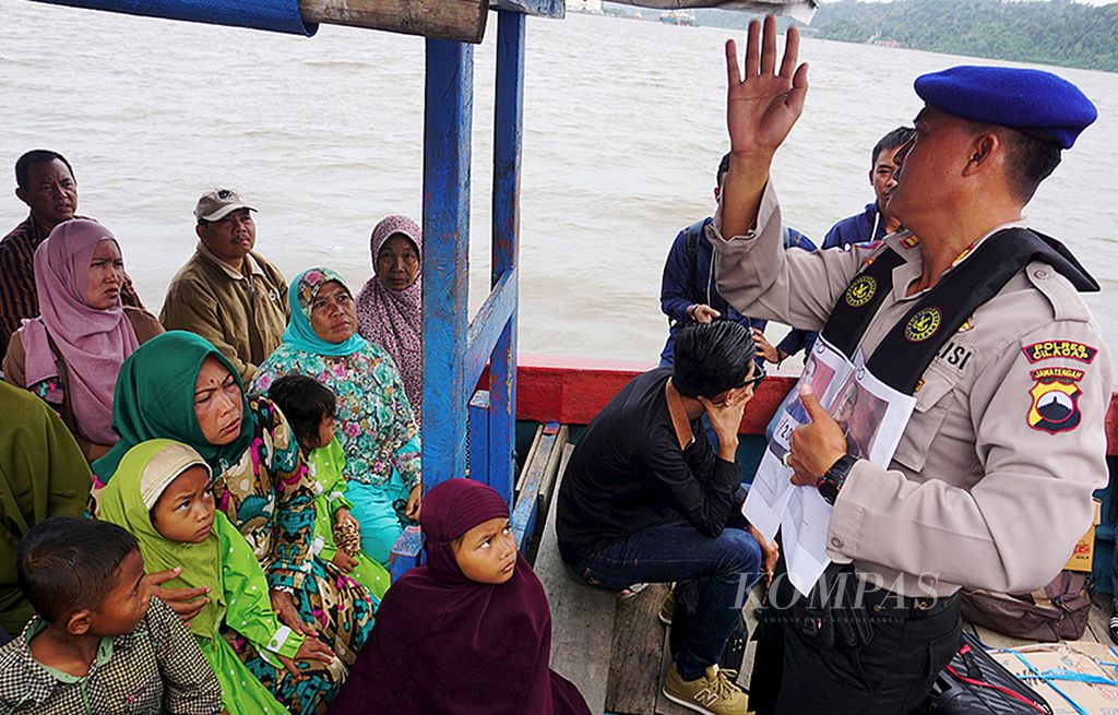Polisi memberikan pengumuman  kepada penumpang kapal di perairan Nusakambangan terkait dua narapidana yang kabur dari Lembaga Pemasyarakatan Nusakambangan, Cilacap, Jawa Tengah, Senin (10/7). Warga diminta melapor jika melihat dua narapidana itu.