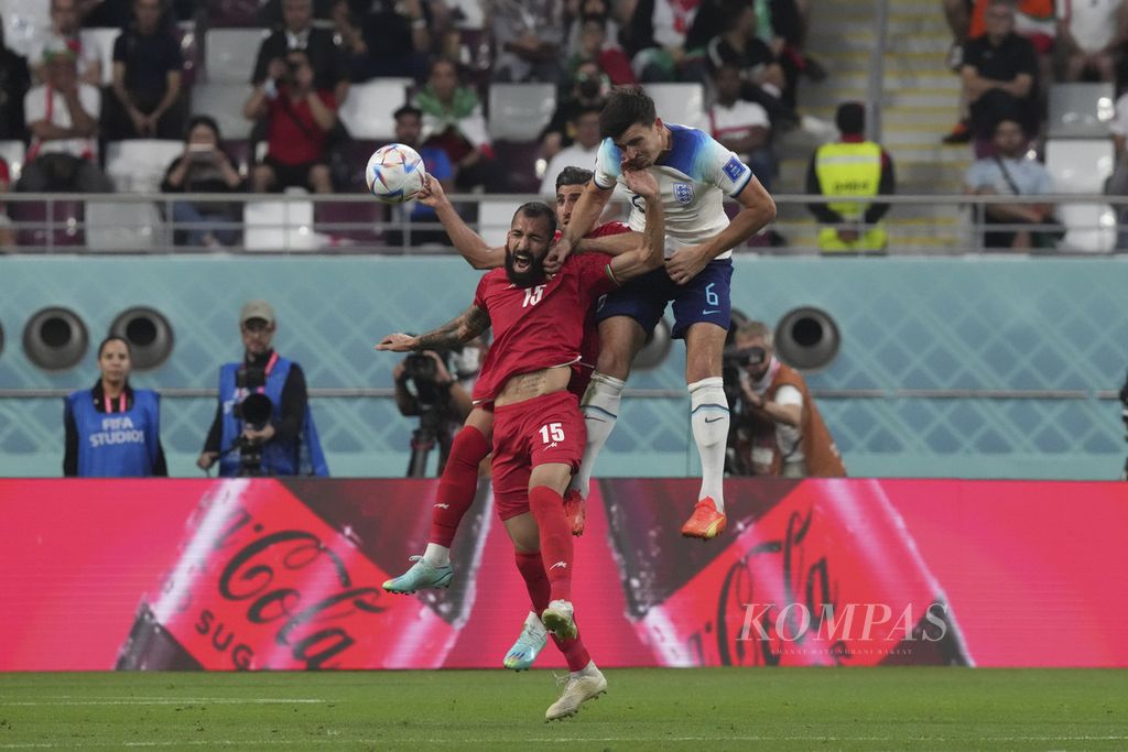 Bek Inggris, Harry Maguire (paling kanan), berebut bola dengan dua pemain Iran di penyisihan Grup B Piala Dunia Qatar 2022 di Stadion Khalifa, Qatar, Senin (21/11/2022). Inggris menang, 6-2, pada laga itu. 