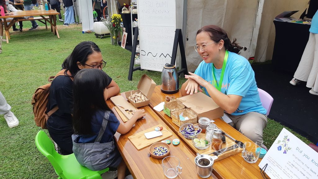 Seorang penjaga stan minuman herbal mengajari pengunjung Piknik Hijau-Hijau cara membuat teh herbal di Jakarta, Sabtu (23/9/2023). Acara ini diadakan oleh Kedutaan Besar Uni Eropa dalam rangka Pekan Diplomasi Hijau UE 2023.