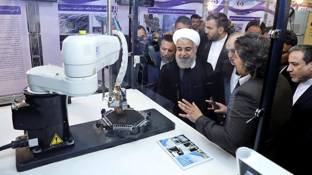 Presiden Iran Hassan Rouhani (tengah) mendengarkan penjelasan tentang pencapaian baru negaranya di bidang nuklir pada upacara peringatan Hari Nuklir Nasional di Teheran, Iran, dalam foto bertanggal 9 April 2018 yang dirilis kantor Kepresidenan Iran. Arab Saudi tak ingin tertinggal dari Iran dalam penguasaan teknologi nuklir.