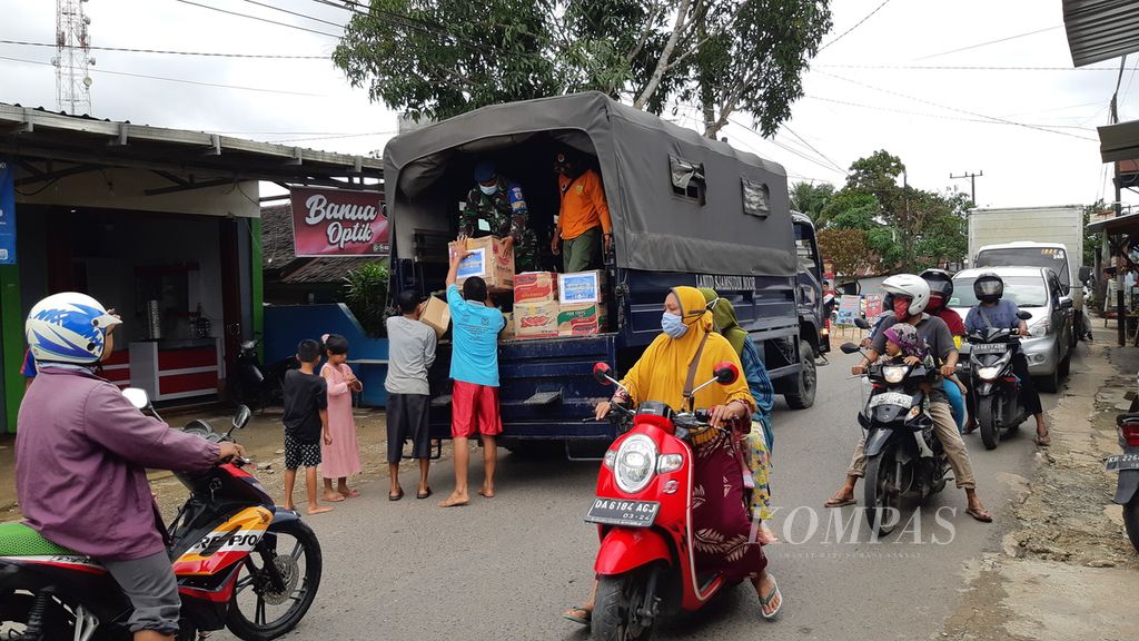 Petugas membagikan bantuan logistik kepada warga terdampak banjir di Kecamatan Sungai Tabuk, Kabupaten Banjar, Kalimantan Selatan, Senin (1/2/2021).