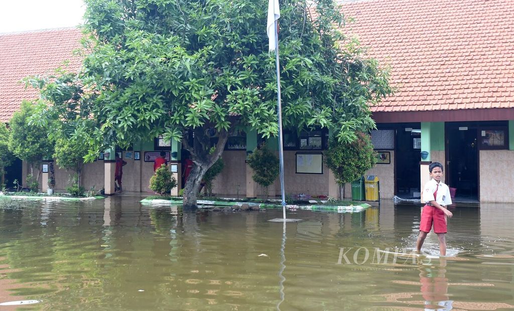 Banjir merendam kompleks SD Negeri Banjarasri di Kecamatan Tanggulangin, Kabupaten Sidoarjo, Jawa Timur, selama tiga minggu, seperti terlihat pada Selasa (11/2/2020). Siswa berharap banjir segera surut agar kegiatan belajar kembali normal. 