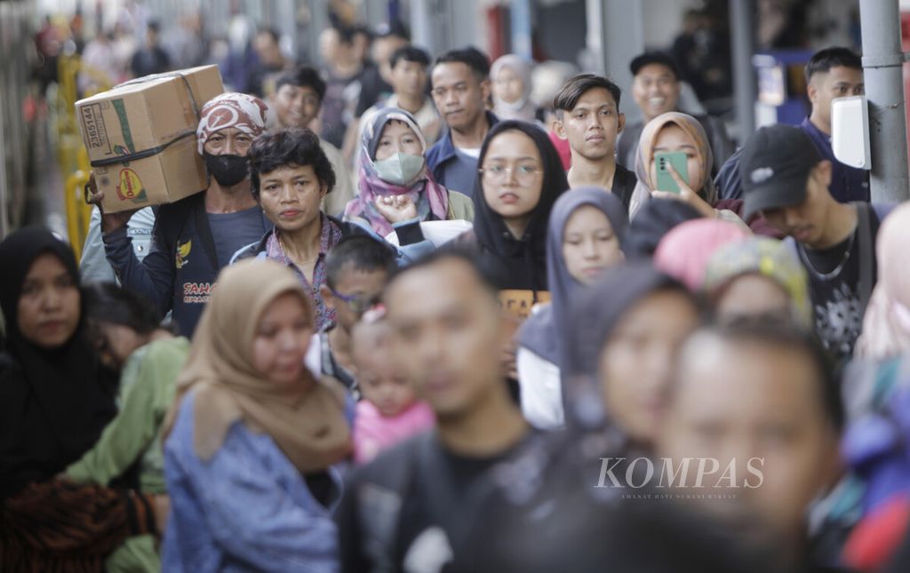 Calon penumpang bergegas masuk menuju Kereta Motis Tengah 1 relasi Pasar Senen-Kutoarjo di Stasiun Pasar Senen, Jakarta, Minggu (7/4/2024).